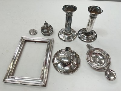 Lot 1124 - Group of silver items including pair of candlesticks, photograph frame, tea strainer, two lids and The East Surrey Regiment desk inkwell