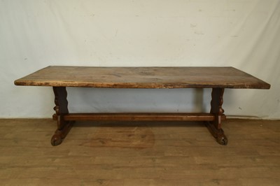 Lot 1326 - 17th century style oak refectory table, with massive single plank slab top, raised on trestle ends and splayed hoof form feet, united by a central stretcher, 240 x 85cm