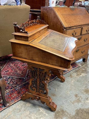 Lot 1338 - Victorian walnut desk, with pierced gallery over hinged stationery compartment and leather inset slope enclosing fitted interior of drawers and pigeon holes, raised on pierced ends and splayed s...