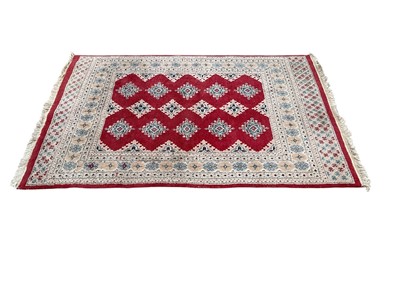 Lot 1374 - Modern machine made Eastern rug with 14 central medallions on red and cream ground, 188cm x 129cm