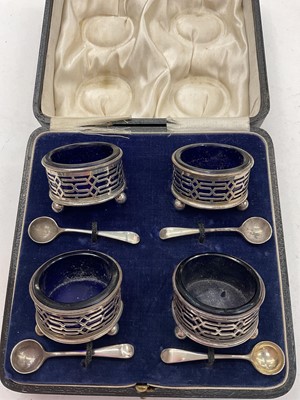 Lot 1159 - 1920s silver four piece condiment set with blue glass liners and four silver salt spoons in fitted case