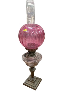 Lot 550 - Victorian brass oil lamp with cranberry glass shade and glass reservoir.