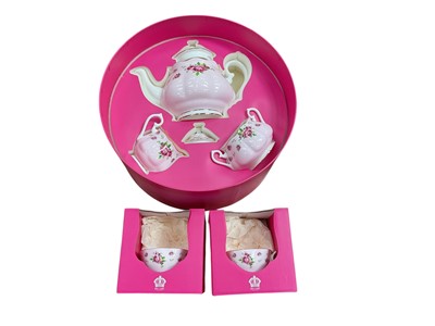 Lot 568 - Royal Albert New Country Roses pattern teapot, milk jug and sugar bowl in a fitted case and two similar tea cups.