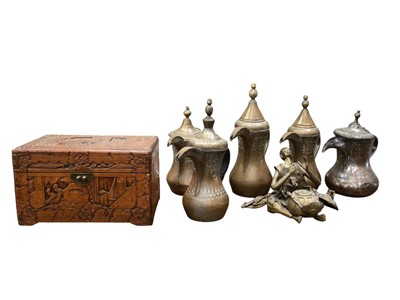 Lot 616 - Four Middle Eastern brass dallahs and one silvered copper, together with a Chinese carved wooden box and a brass figure