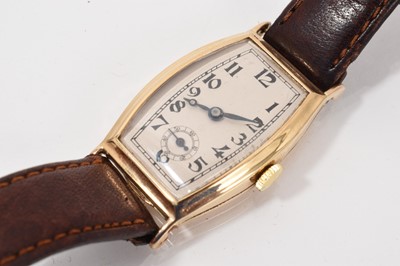 Lot 777 - 1930s 9ct gold wristwatch, the cream dial with black Arabic numerals and subsidiary seconds in a curved 9ct gold tonneau shape case (Glasgow import hallmarks 1934)