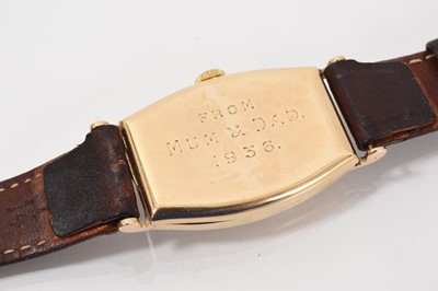 Lot 777 - 1930s 9ct gold wristwatch, the cream dial with black Arabic numerals and subsidiary seconds in a curved 9ct gold tonneau shape case (Glasgow import hallmarks 1934)