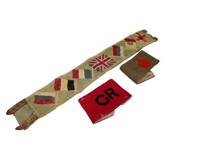 Lot 687 - First World War tapestry stable belt decorated with the flags of the allied powers, together with two British military issue armbands (2).