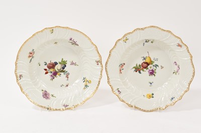 Lot 25 - A pair of mid 18th century Meissen soup plates, painted to the wells with sprays of fruit and flowers, with spiral-moulded rims and cavettos, moulded with basketweave panels, blue crossed swords...