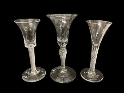 Lot 50 - Mid-18th century air twist stem wine or cordial glass, with a flared bell shape bowl on a knopped stem, together with two other mid-18th century air twist stemmed cordial glasses.
