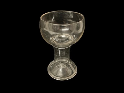 Lot 51 - An unusual clear Roemer wine glass, probably late 17th or 18th century, the wide bowl on a tapering hollow shaft and a trumpet shaped blown foot with downwardly folded rim and kick-in foot, mill...