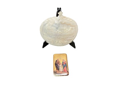 Lot 2440 - Mother of pearl shell carved in relief with the Last Supper, and a 19th century porcelain plaque painted with the Christ child (2)