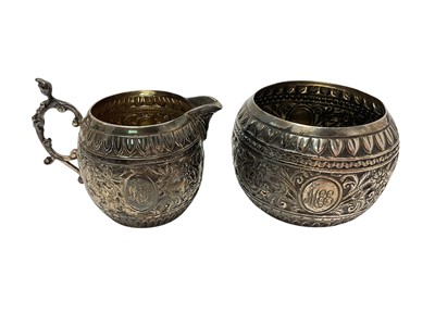 Lot 19 - Victorian silver cream jug and matching sugar bowl, both with embossed floral scroll decoration and engraved 'MEE' monogram