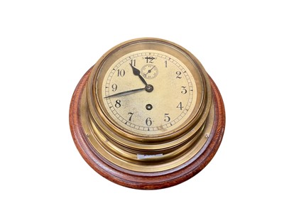 Lot 2443 - Two brass ship's bulkhead clocks, including one with wooden back, with dials measuring 15cm and 17cm diameter