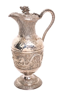 Lot 257 - 19th century Chinese silver claret jug with central band of relief decoration depicting a 5 clawed dragon chasing a flaming pearl, hinged cover with dragons head finial and simulated bamboo handle.