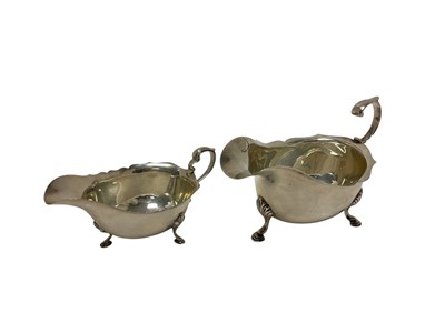 Lot 246 - George V silver sauce boats of helmet form, raised on three hoof feet, (Chester 1930), maker Stokes & Ireland Ltd, together with another George V silver sauce boat (Edinburgh 1936)