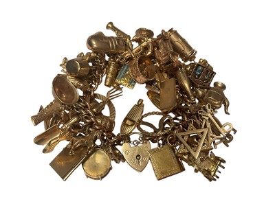 Lot 18 - 9ct gold curb link charm bracelet with padlock clasp extensive collection of 9ct gold and yellow metal novelty charms