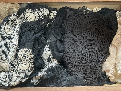 Lot 2146 - Box containing two large black Chantilly lace mantillas, plus a quantity of antique and later lace including approximately 4 meters of wide black bobbins lace trim, long wide chantliiy lace stol...