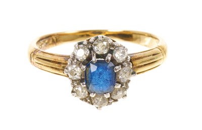 Lot 430 - Late Victorian 18ct gold sapphire and diamond cluster ring with central blue mixed cut sapphire surrounded by eight old cut diamonds in claw setting on a gold shank with fancy shoulders