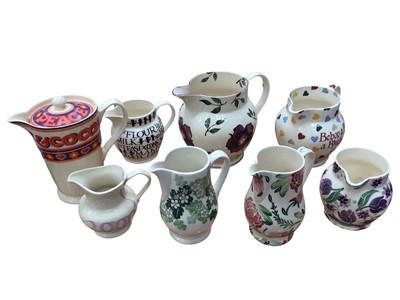 Lot 1197 - Collection of Emma Bridgewater jugs, including Peace, Love & Cocoa jug with lid, Bebop a Rebop a Rhubarb Pie jug and five others (8)