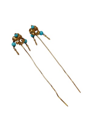 Lot 130 - Pair of yellow metal hat pins with hinged floral mounts and suspended blue beads