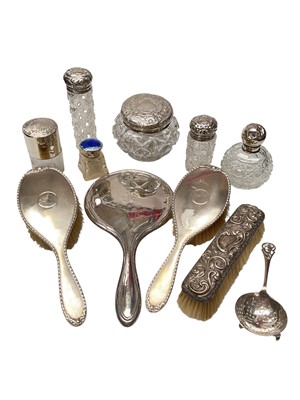 Lot 136 - Silver mounted dressing table mirror, brushes, glass perfume bottles and jars, and a silver tea strainer