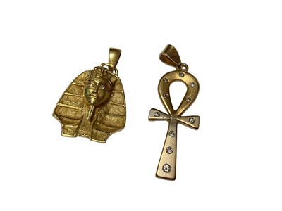 Lot 178 - Egyptian gold (stamped 750) pharaoh head pendant with diamond set eyes and an Egyptian gold diamond set cross pendant (2)