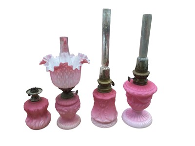 Lot 2604 - Four Victorian pink satin moulded glass oil lamps , one with shade (4)