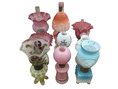 Lot 2607 - Nine late Victorian and Edwardian small oil table lamps with shades including ruby glass shades and cat mask moulded blue tinted shade 24-34cm high