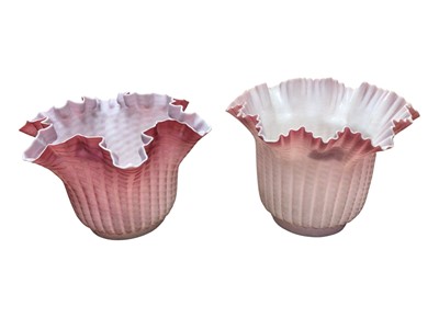 Lot 2608 - Two Victorian pink satin glass oil lamp shades with handkerchief borders 15-17cm high