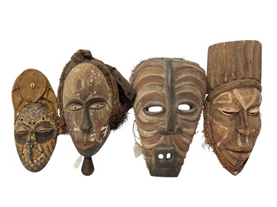 Lot 753 - Four African tribal masks, including a Kuba mask with shell, cloth and bead ornament, Yoruba mask, Fang mask and a polychrome painted Basonge mask. (4)
