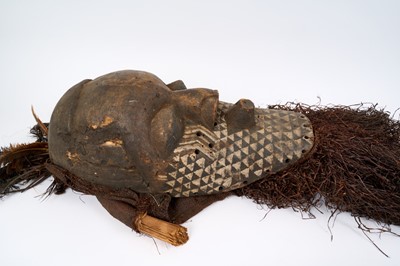 Lot 754 - Antique Kuba Pwoom Itok mask, with stylised features and white pigment, with feathers and raffia, the wooden part approximately 48cm high