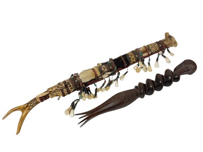Lot 759 - Dyak headhunter sword, with antler handle and embellished with polychrome ornament and hung with teeth, 68cm long, together with cannibal fork. (2)