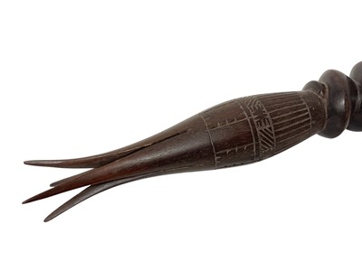 Lot 759 - Dyak headhunter sword, with antler handle and embellished with polychrome ornament and hung with teeth, 68cm long, together with cannibal fork. (2)