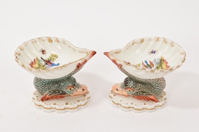 Lot 84 - Pair of Berlin porcelain salts, of shell form, painted with exotic birds and insects, supported by mythical dolphins on shaped bases, underglaze blue marks to bases, 6.5cm high