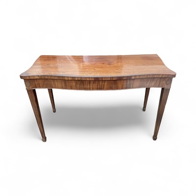 Lot 1290 - George III mahogany serving table, in the manner of Hepplewhite, of serpentine outline, with patera headed square tapered legs and spade feet