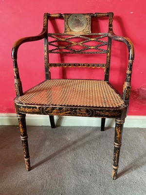 Lot 1292 - Regency caned and black lacquered open armchair, the lattice back centred with portrait reserve, raised on ring turned legs