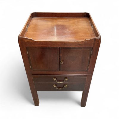 Lot 1293 - George III mahogany pot cupboard, with gallery top pierced with carrying handles, enclosed by cupboard doors, raised on square supports