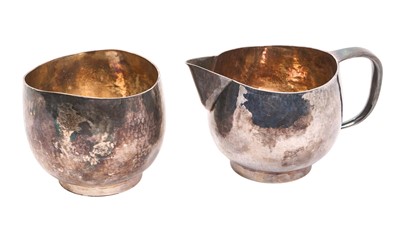 Lot 223 - Contemporary white metal milk jug and sugar bowl, each with overall planished decoration, and raised on circular foot rims, apparently unmarked, milk jug 7.4cm in overall height, all at 11ozs, (...