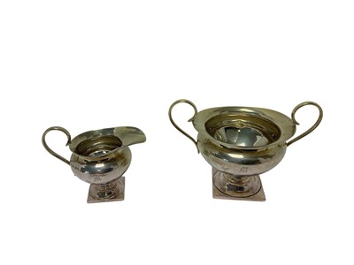 Lot 232 - Edwardian silver milk jug and matching sugar bowl, each with engraved initial 'M' and raised on a square pedestal foot, (Chester 1906), maker Walker and Hall, sugar bowl 9.8cm in overall height,...