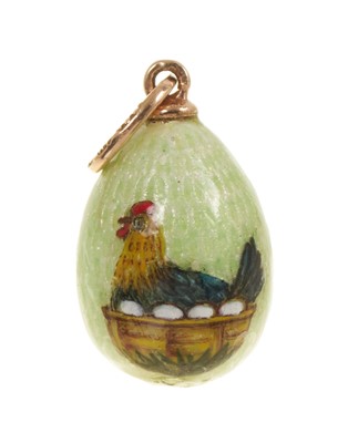 Lot Russian goals and guilloché enamel egg pendant depicting a hen sitting on a basket of eggs, on green ground, the gold mount with Fabergé marks