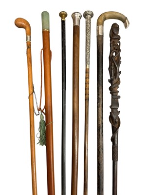 Lot 812 - Elaborate 19th century carved hardwood stick with serpent and heart motifs, together with six further decorative sticks. (7)
