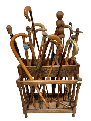 Lot 813 - Collection of approximately 20 sticks and a shooting stick, housed in an oak stick stand