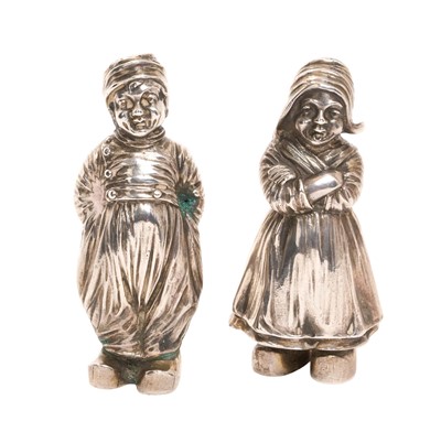 Lot 313 - Two Dutch silver pepper casters in the form of children in National dress, import marks