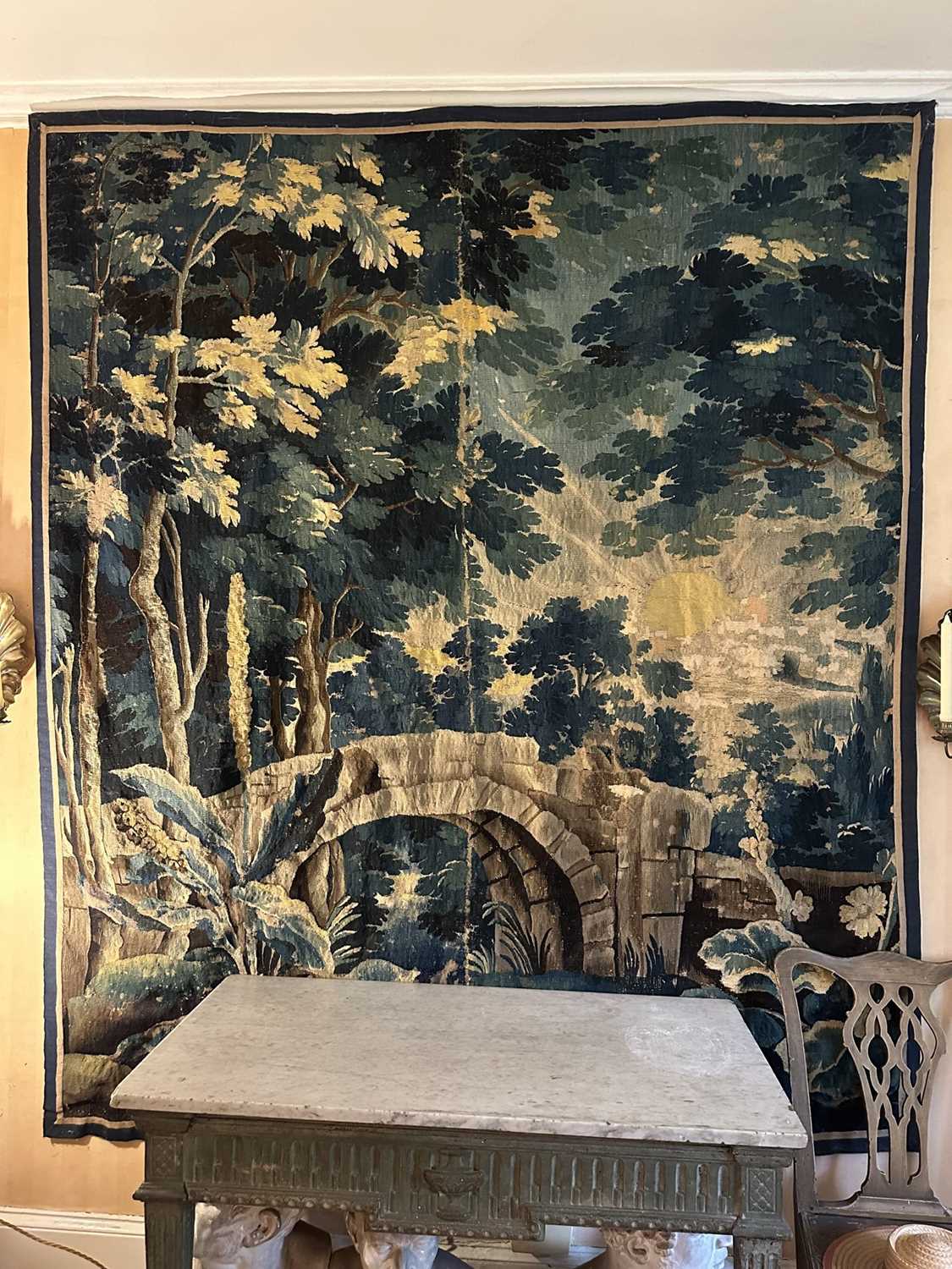 Lot 1502 - Flemish, late 17th / early 18th century Verdure tapestry depicting a sunrise over a bridge Provenance: Joanna Booth, Kings Road, London, 29th September 1990