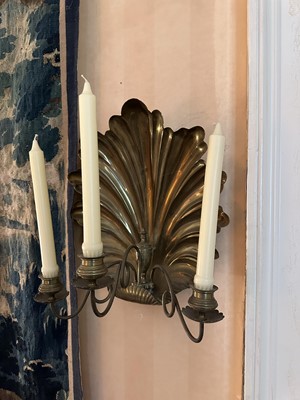 Lot 1504 - Pair of antique brass wall sconces with shell-shaped backs and three scroll candle arms