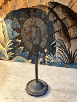 Lot 1513 - 19th century, or earlier, painted metal double-sided table screen depicting figures within a sunburst, on circular base