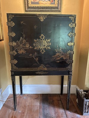 Lot 1522 - Late 17th / early 18th century Chinese lacquer cabinet on stand, the twin hinged doors decorated with landscapes, brass strap hinges, enclosing an arrangment of drawers, on square legs