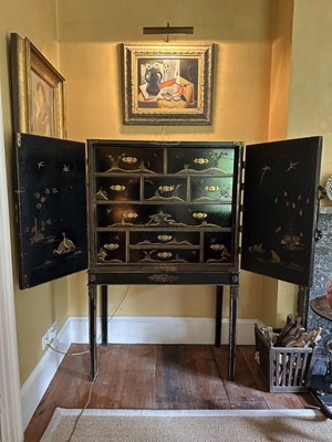 Lot 1522 - Late 17th / early 18th century Chinese lacquer cabinet on stand, the twin hinged doors decorated with landscapes, brass strap hinges, enclosing an arrangment of drawers, on square legs