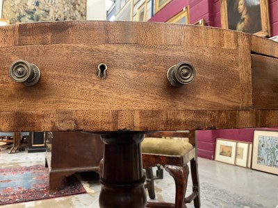 Lot 1529 - 19th century mahogany drum table with crossbanded top and an arrangement of drawers, on turned column and three splayed legs terminating on brass paw castors