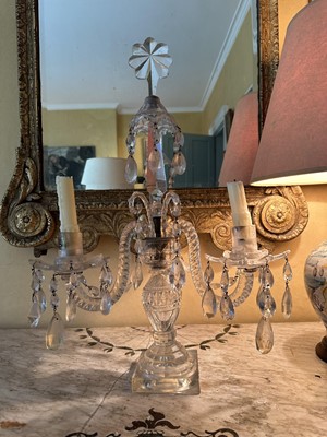 Lot 1537 - George III glass twin branch candelabra, scroll arms with prismatic drops, on urn shaped column and square base, 57cm high